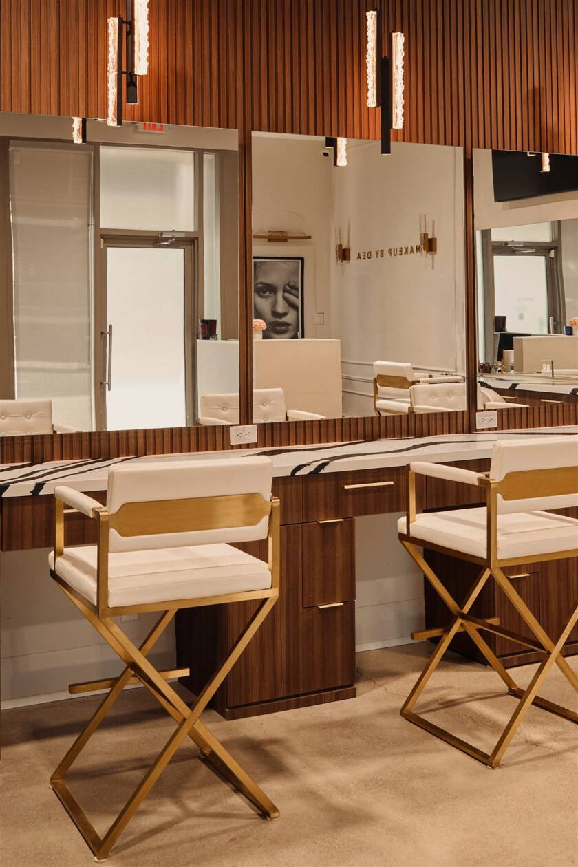Gold and ivory makeup chairs at marble vanity stations