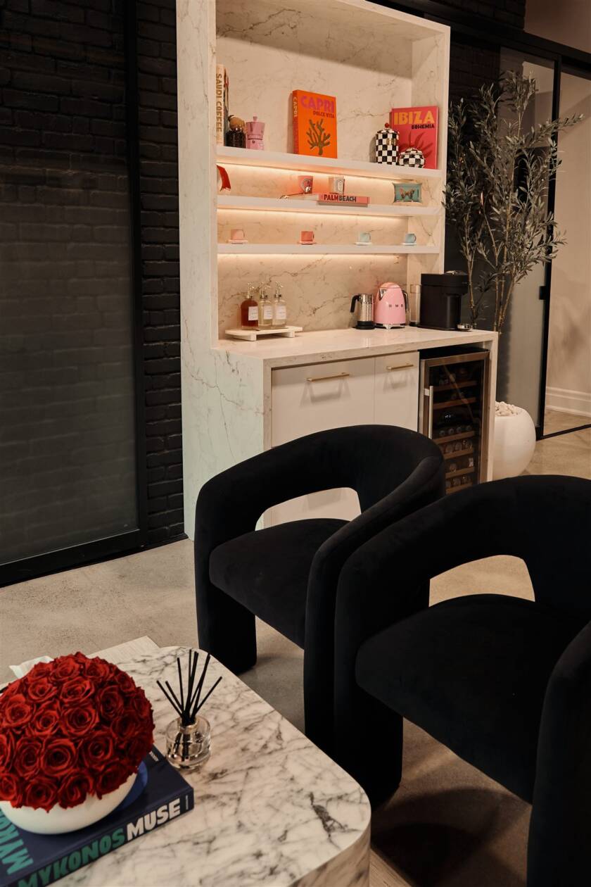 Client lounge with velvet chairs and coffee bar